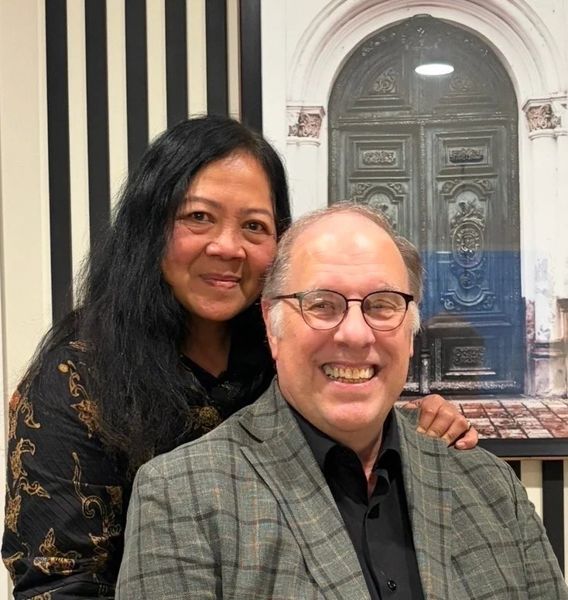 Mel Berglund smiling, standing with his wife